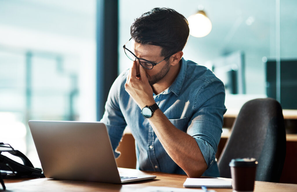 Stressed, Tired And Frustrated Business Man With Headache At Night From Burnout Or Making Mistake On Laptop. Overworked Creative Entrepreneur Failing To Meet Late Office Deadline Or Working Overtime